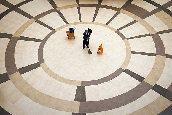 An employee cleans the floor inside a shopping mall in Mumbai.