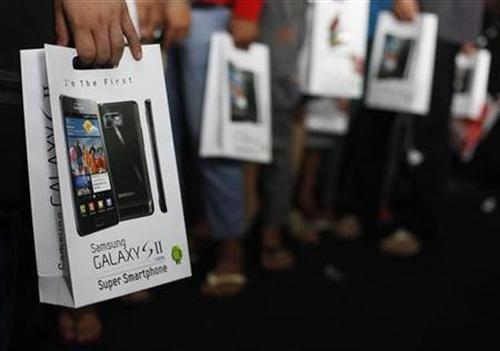 Customers hold their newly purchased Samsung Galaxy phone in Jakarta