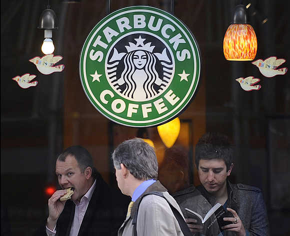 A pedestrian passes a branch of Starbucks Coffee in central London.