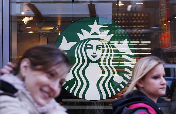 Pedestrians walk past the new Starbucks logo on a store in Times Square in New York.