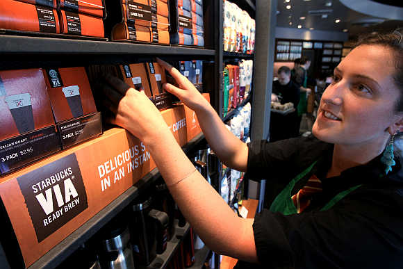 Starbucks barista Amy Hekinson arranges their new Via coffee product on the shelves at the Queen Anne Hill Starbucks store in Seattle, Washington.