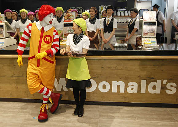 McDonald's Ronald McDonald chats with a counter staff in Tokyo.