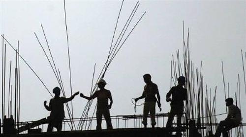 Indian labourers work on a high-rise building construction site in Kolkata