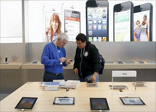 A customer is helped by an Apple employee while looking over the iPad mini after the device went on sale at Apple's retail store in Palo Alto.