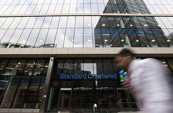 A man walks past a Standard Chartered bank in London.