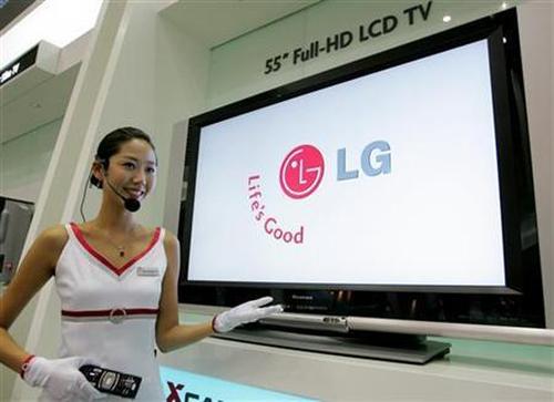A saleswoman demonstrates the use of an LG Electronics 55-inch Full-HD LCD TV