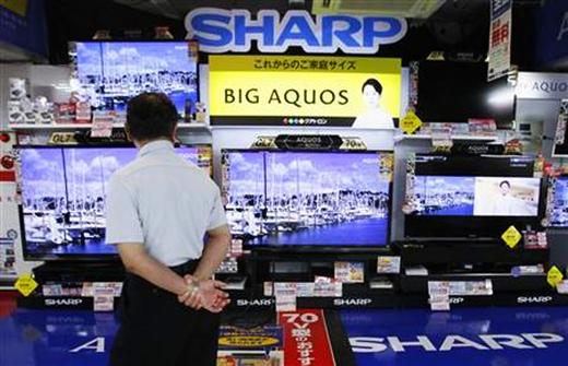 A man looks at Sharp Corp's Aquos TVs displayed at an electronics store