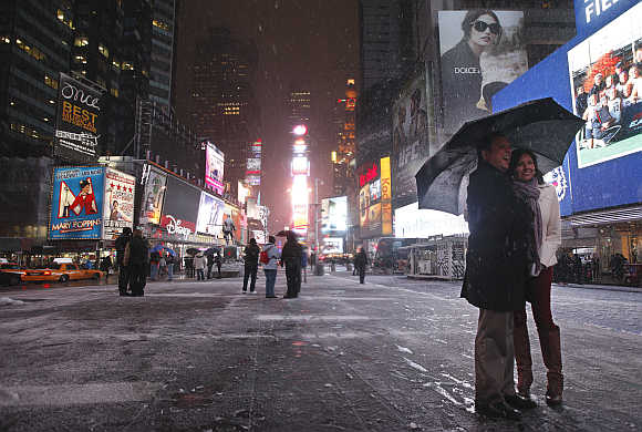 A couple have a picture taken during a snow storm in New York's Times Square.