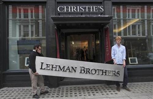 Christie's employees pose for a photograph with a Lehman Brothers sign