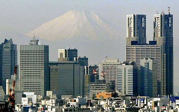 Mt Fuji looms over skyscrapers in Tokyo's Shinjuku district.
