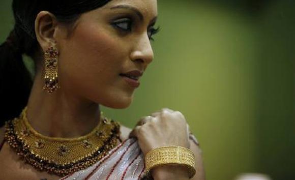 A model poses with gold jewellery during a jewellery show.