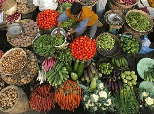 A vendor arranges vegetables at a market in Siliguri.