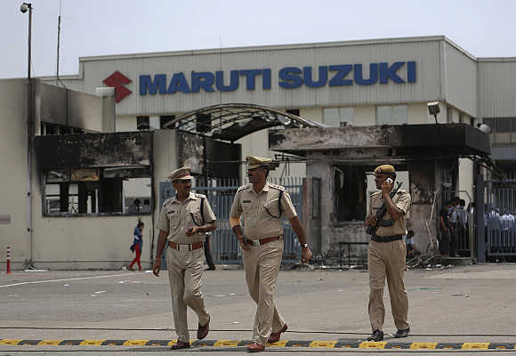 Police officials walk outside the Maruti Suzuki's plant in Manesar.