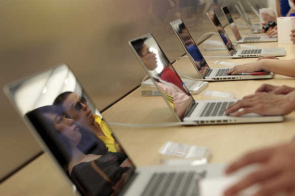 Customers check Apple laptops in Shanghai.