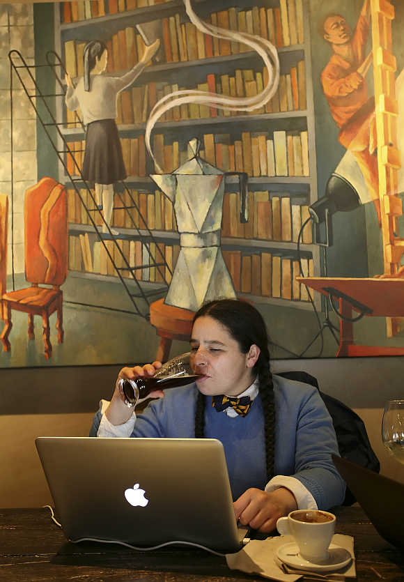 Nadine Maestas enjoys a beer after her coffee while studying at Starbucks' Roy Street Coffee and Tea in Seattle, Washington.