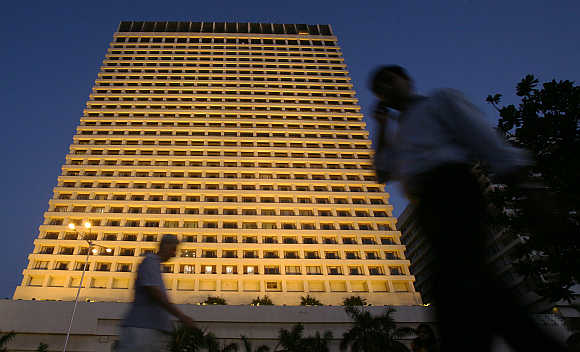 People walk past the lit-up Trident hotel in Mumbai.