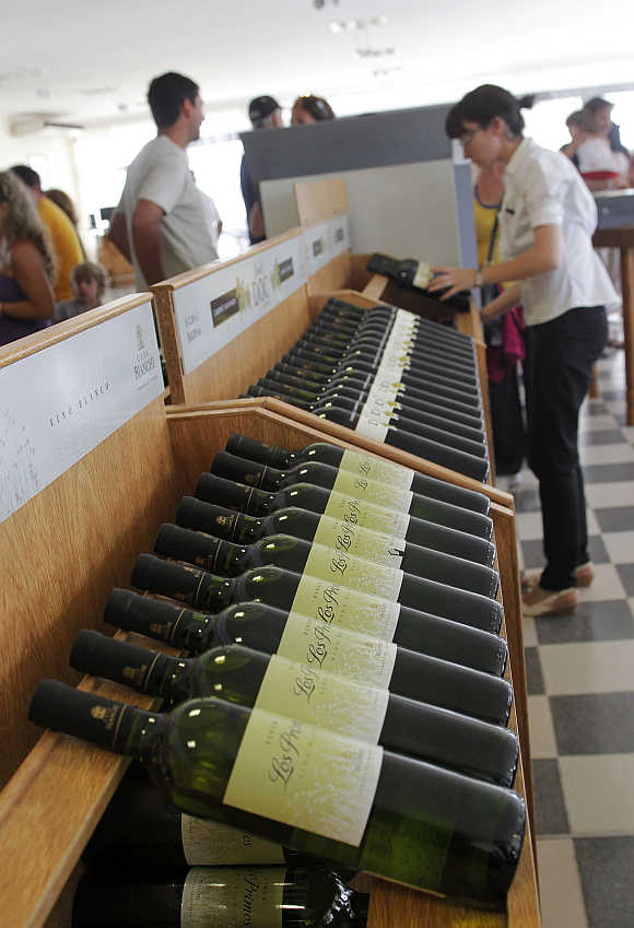 A wine expert places bottles of wine on display in a shop in Casa Bianchi in San Rafael, Argentina.