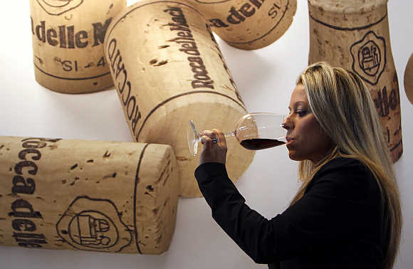 A woman tests a glass of red wine at the Vinitaly wine expo in Verona, Italy.
