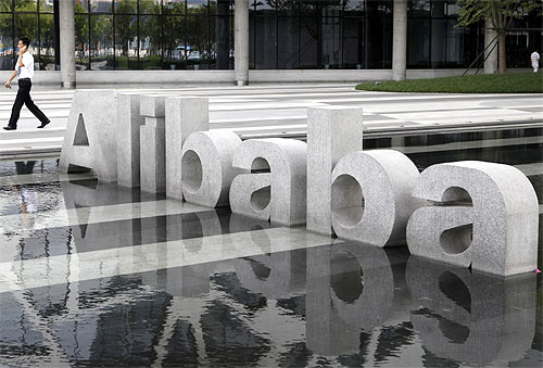 -A man walks past a logo of Alibaba (China) Technology Co. Ltd at its headquarters on the outskirts of Hangzhou.