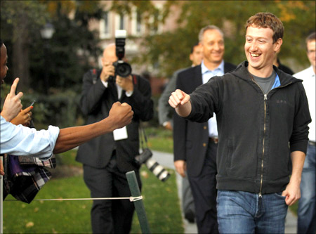 Facebook founder and CEO Mark Zuckerberg fist bumps a student at Harvard University in Cambridge, Massachusetts.