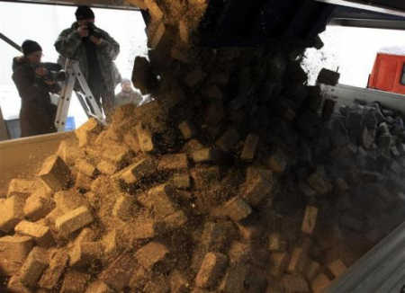 Four tonnes of shredded and compressed banknotes are loaded onto a truck.