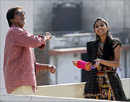 Bollywood actor Amitabh Bachchan (L) flies a kite during a shoot for a movie to promote tourism in Gujarat.