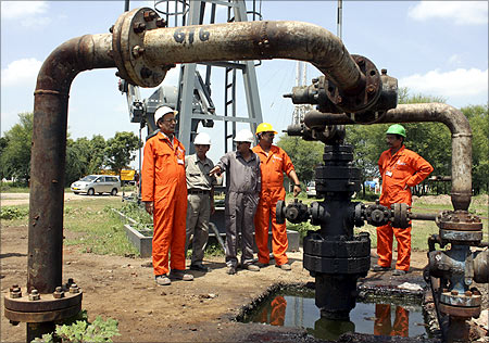 Engineers of Oil and Natural Gas Corp (ONGC) stand inside the Kalol oil field.