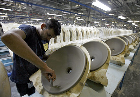 An employee works inside the Duravit production site, which produces wash basins and other toilet goods, at Tarapur.