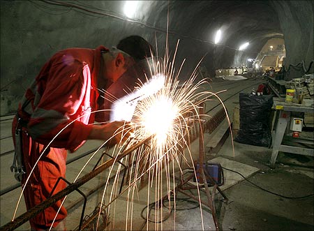 A worker welds a steel grid.