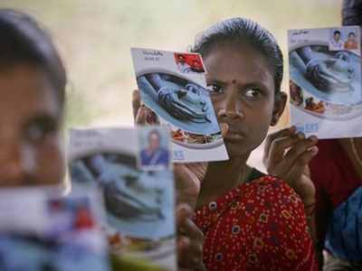 Loan borrowers show pass books given to them by a micro finance company