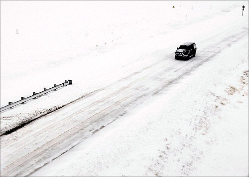 A truck travels along Highway 40 as snow covers the highway and the surrounding plains, west of Hays, Kansas.