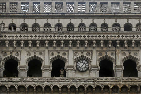 A security personnel watches through a pair of binoculars from the historical monument Charminar in Hyderabad.
