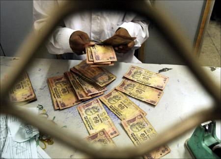 Indian currency notes are stapled to form a garland at a shop in Jammu.