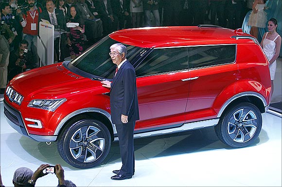 Shinzo Nakanishi, chief executive and managing director of Maruti Suzuki, poses with company's new compact SUV XA Alpha car after unveiling it at India's Auto Expo in New Delhi.