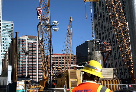 A worker stands in front of a construction site in San Francisco.