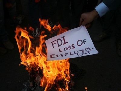 An activist of Shiv Sena burns a pamphlet during a protest against Foreign Direct Investment.