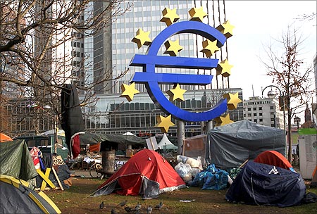 Tents of the 'Occupy Frankfurt' movement are pictured next to the Euro currency sign sculpture in front of the European Central Bank.