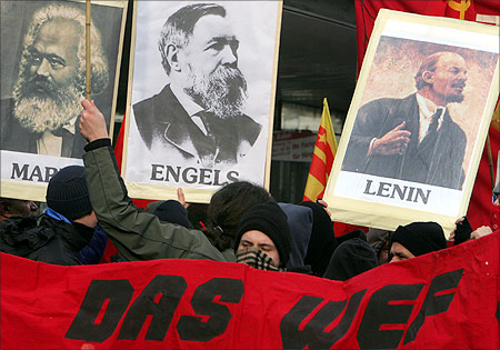 Protesters march in the streets with portraits of Karl Marx, Friederich Engels and Vladimir Lenin during a demonstration.