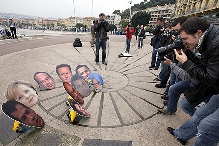 Photographers take photo of masks showing G20 leaders during an anti G20 demonstration to protest against globalisation in Nice ahead of the G20 summit.