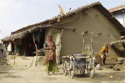 Villagers smile outside their mud house in Khun village near Dholera town in Gujarat.