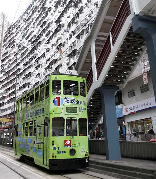 A tram passes by a marketplace in downtown Hong Kong.