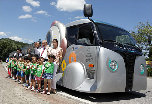 People pose in front of a wireless electric tram during its launch ceremony at Seoul Grand Park in Gwacheon, south of Seoul.