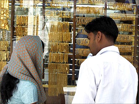 Customers look at gold in a jewellery shop in Amman.