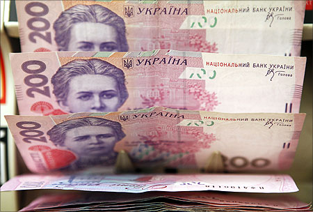 A cashier counts Ukrainian hryvnia banknotes at a shop in Kiev.