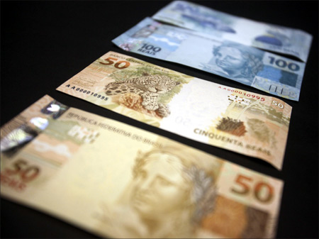 A photo illustration of new Brazilian R$50 and R$100 real currency notes after their launch in Brasilia.