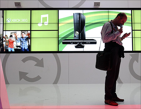 A man checks his messages on his smartphone at the Microsoft booth during the 2012 International Consumer Electronics Show (CES) in Las Vegas.