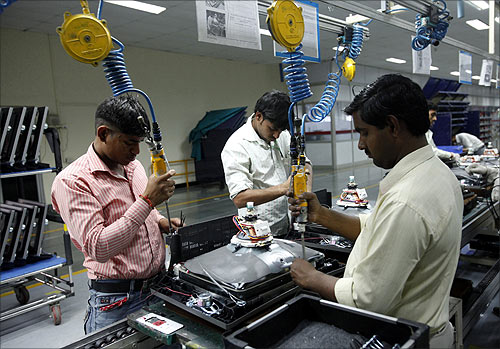 Workers at LG Electronics India Pvt Ltd. assemble television sets inside a factory at Greater Noida.