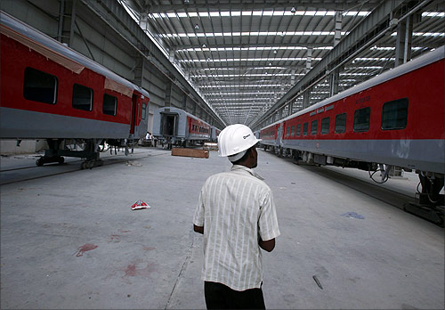 A worker walks past semi-finished rail bogies in a rail coach factory in Uttar Pradesh.