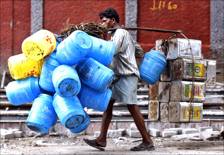 A man carries empty oil containers to a recyclable factory in Kolkata.