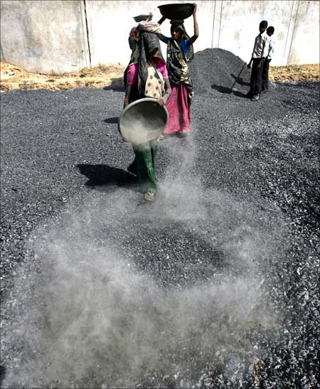 Labourers work at a road construction site on the outskirts of Ahmedabad.